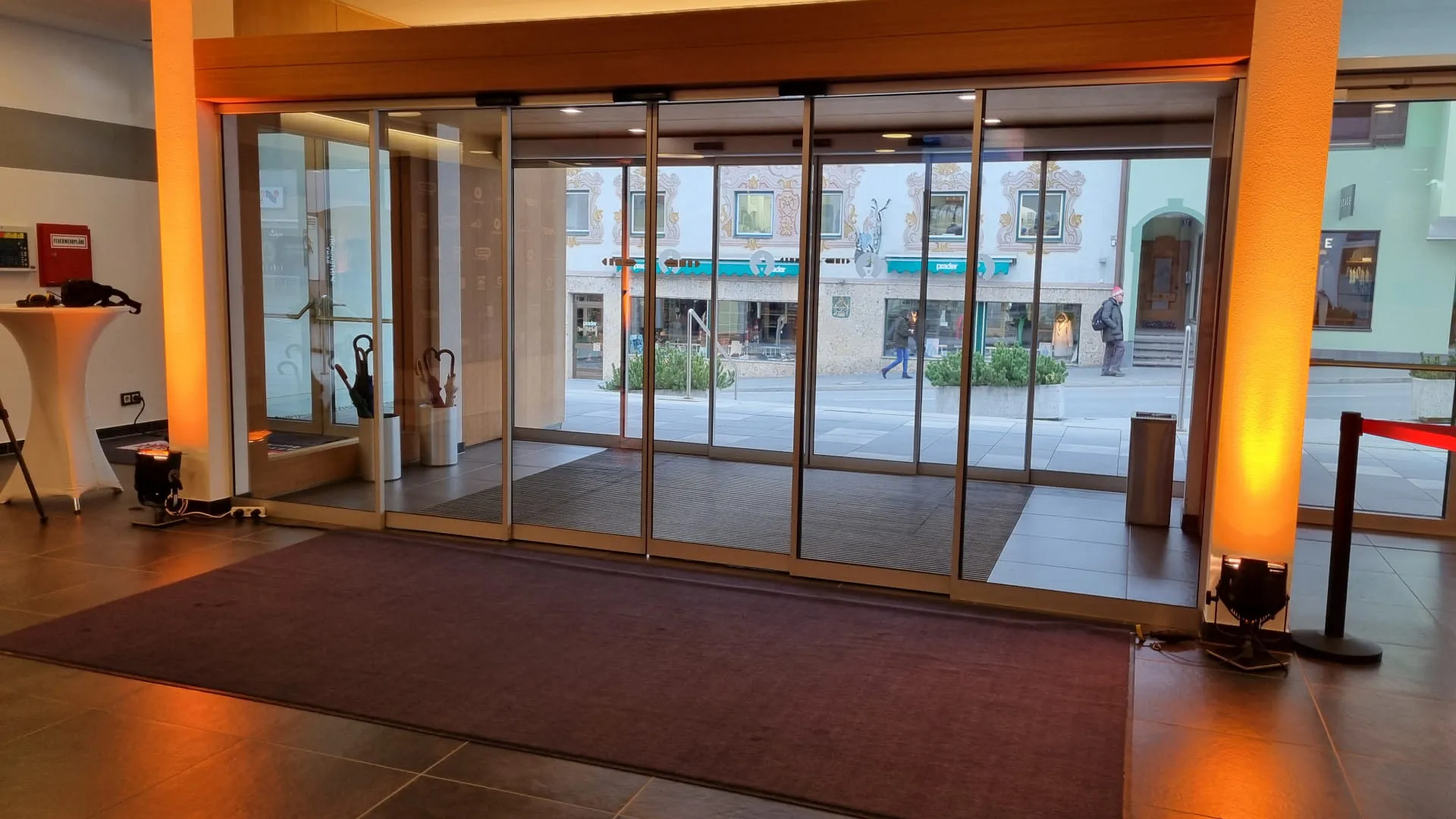 Eingang mit Glastüren und einem Teppich in einem Gebäude