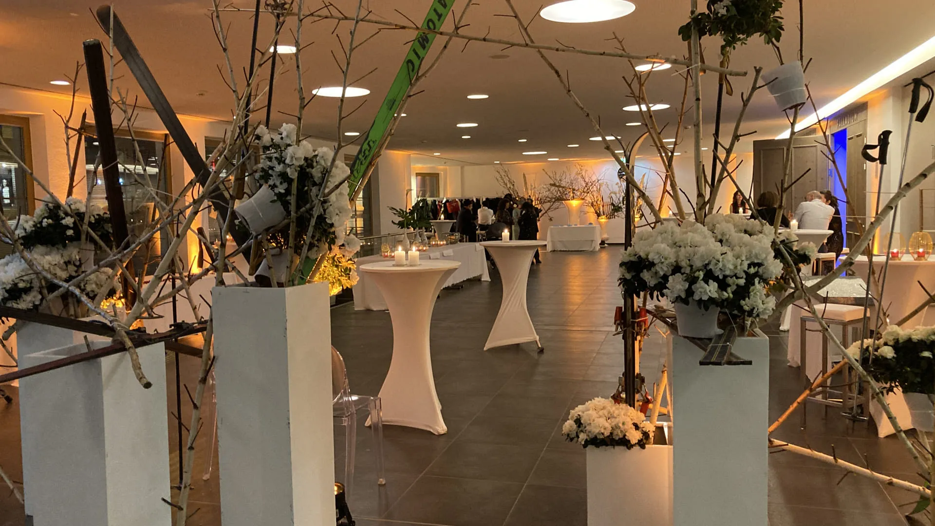 Elegante Eventlocation mit Blumen und Skiern als Dekoration.