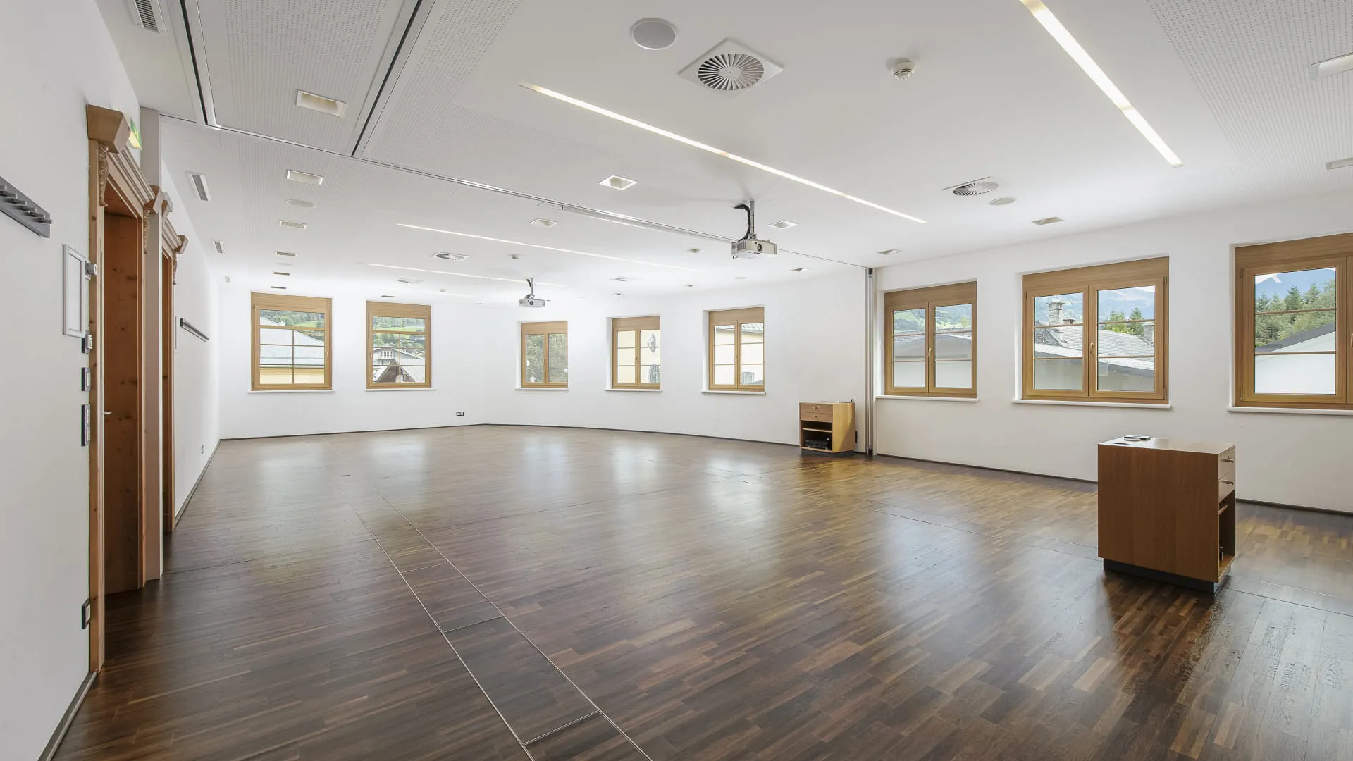 Leerer Raum mit Holzfußboden und großen Fenstern