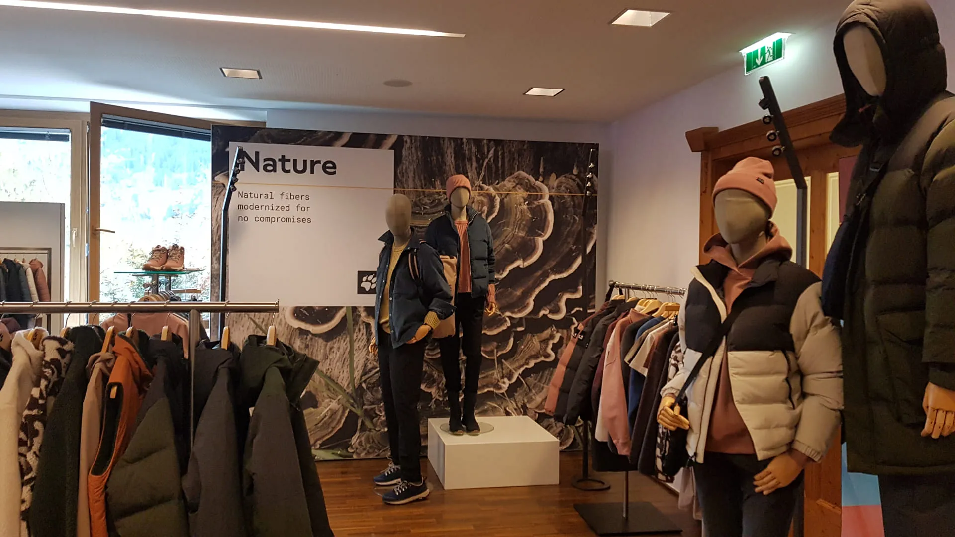 Ein Bekleidungsgeschäft mit Mannequins und einer Wanddekoration.