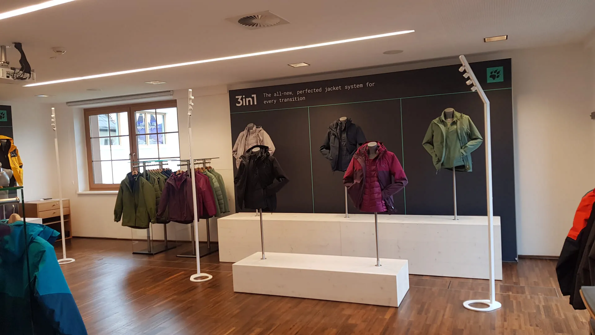 Modegeschäft mit Jackenpräsentation und Wandgestaltung