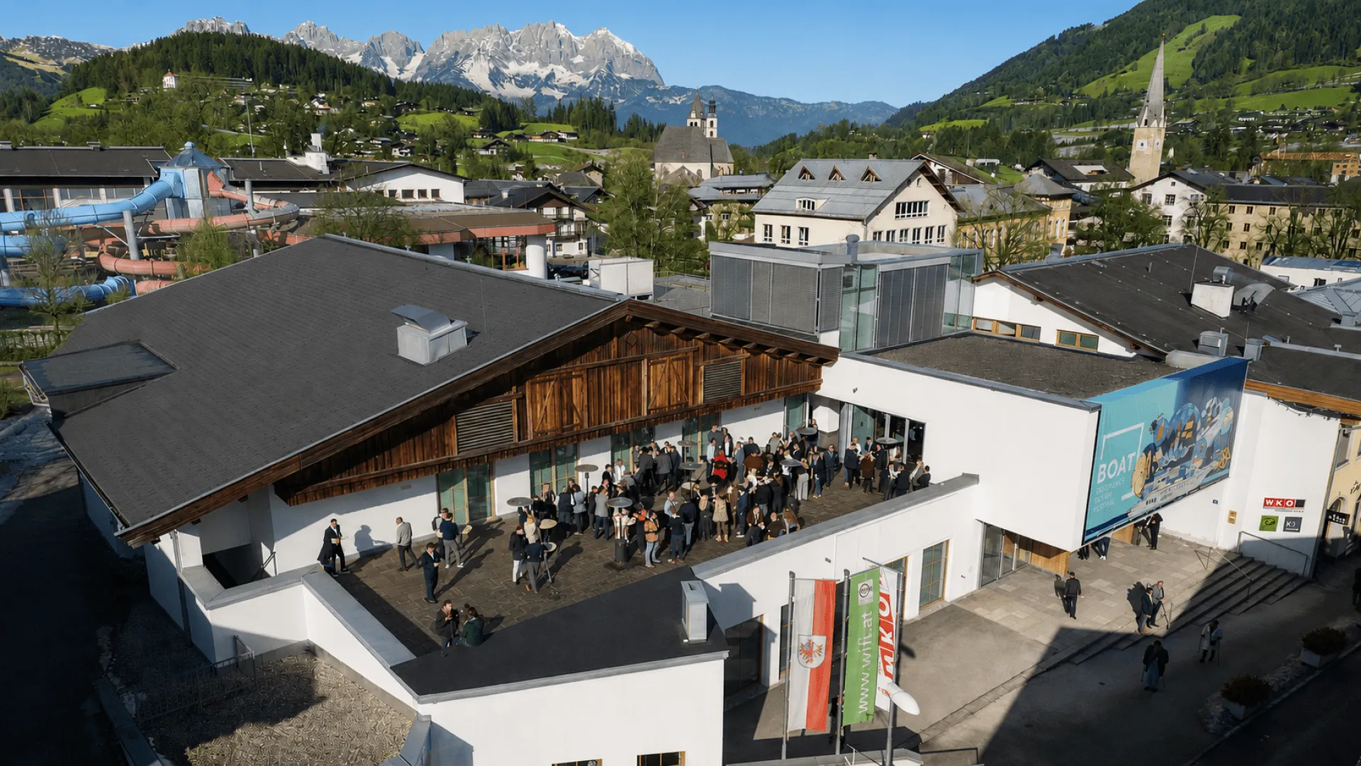Luftaufnahme eines Gebäudes mit Terrasse und Bergen im Hintergrund