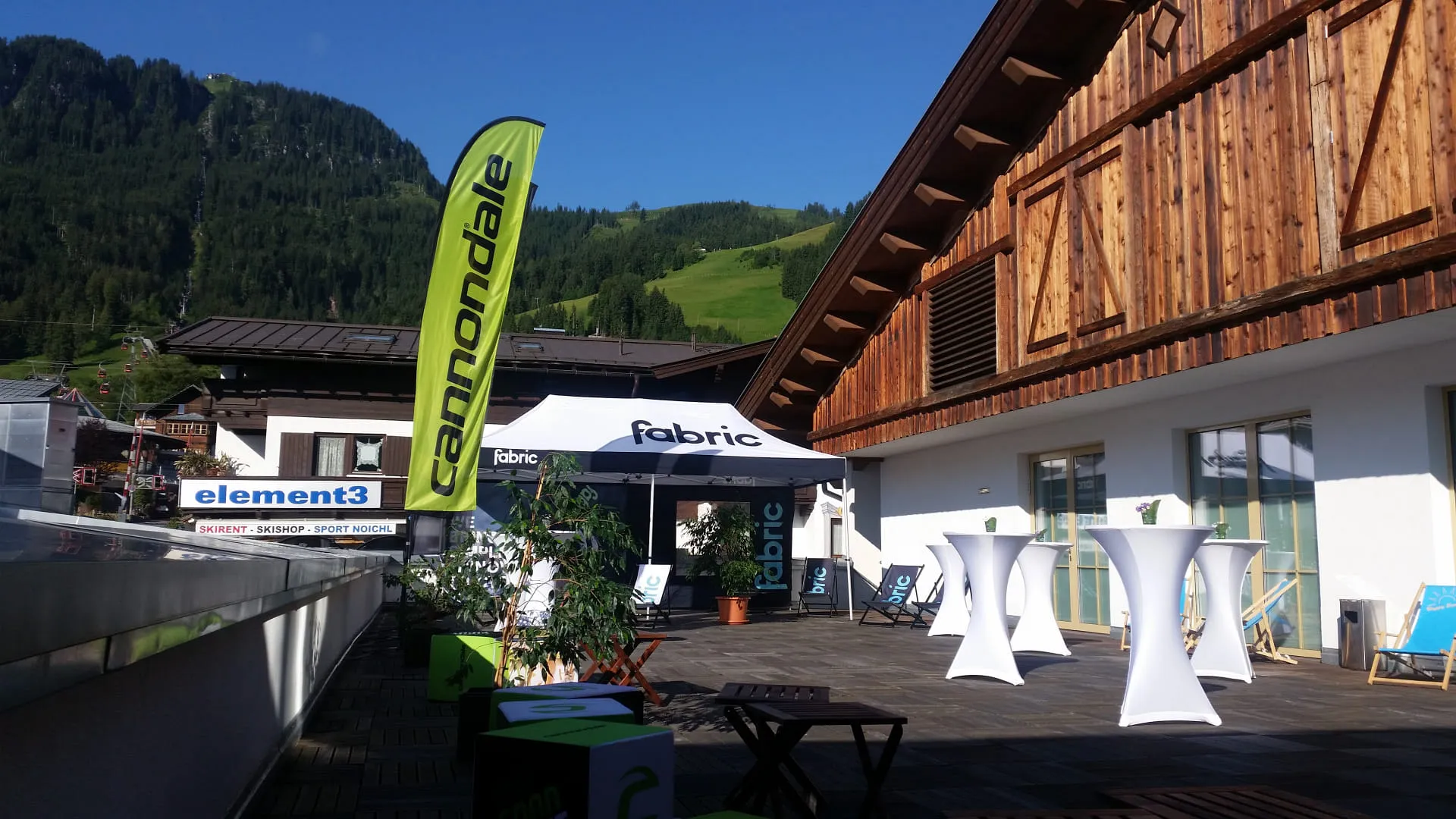 Terrasse mit Werbung von Cannondale und Fabric bei Berglandschaft