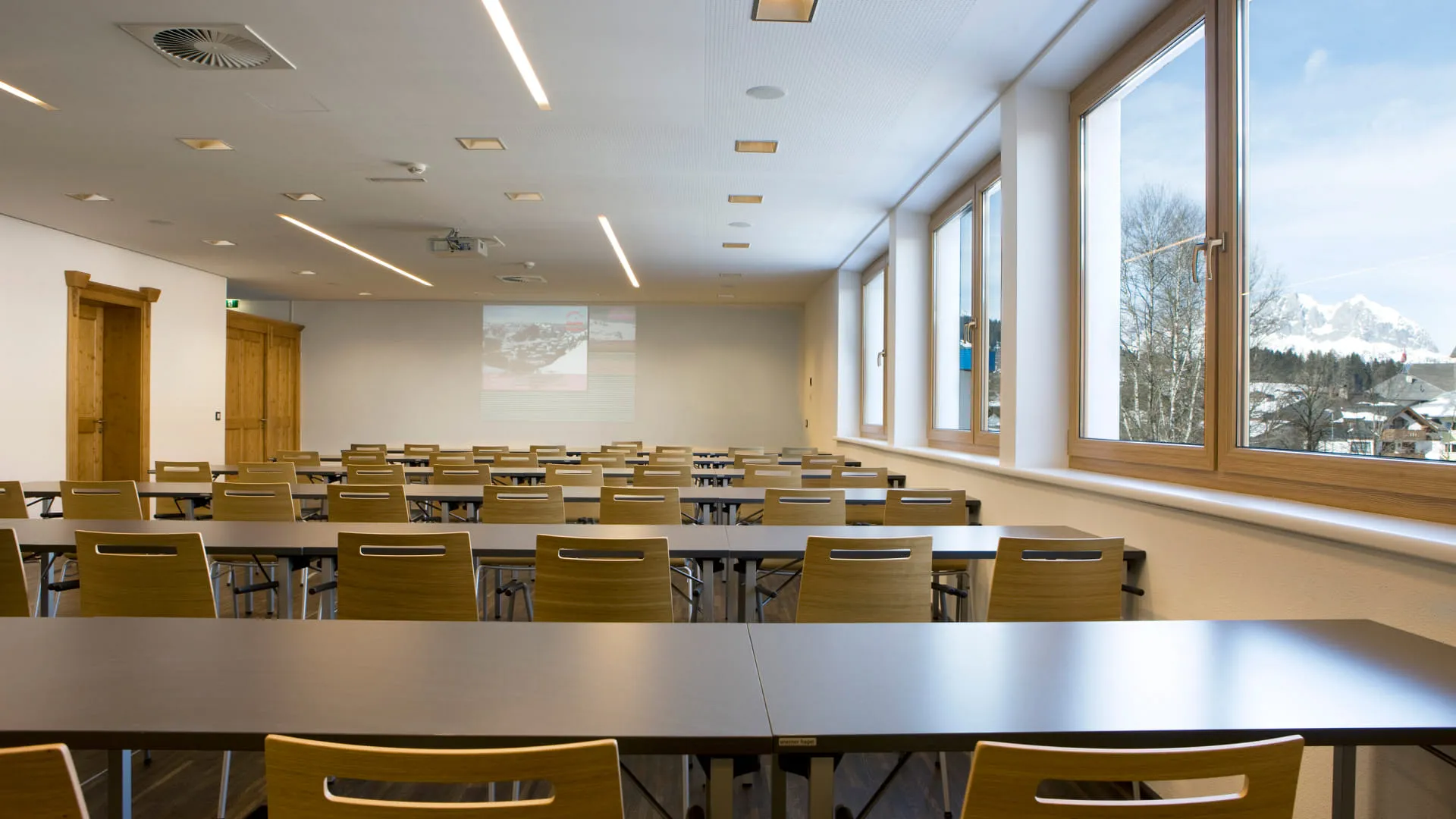 Konferenzraum mit Tischen und Fenstern zur Aussicht.